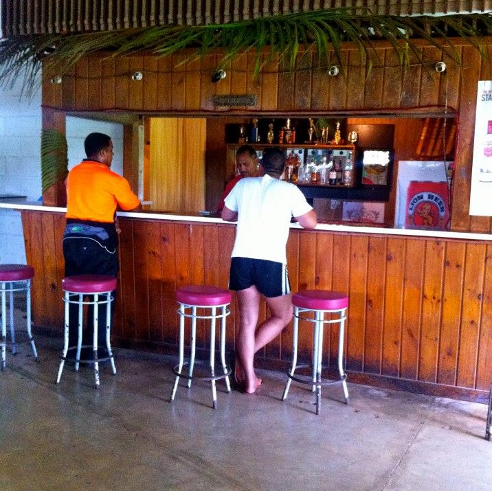 a couple of people standing at a bar