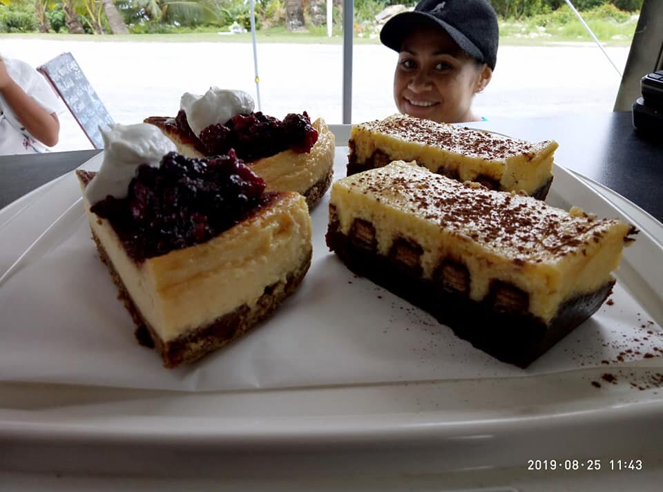a person is smiling at a table with desserts