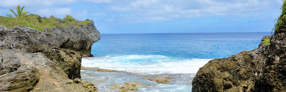 a rocky beach with a body of water in the background