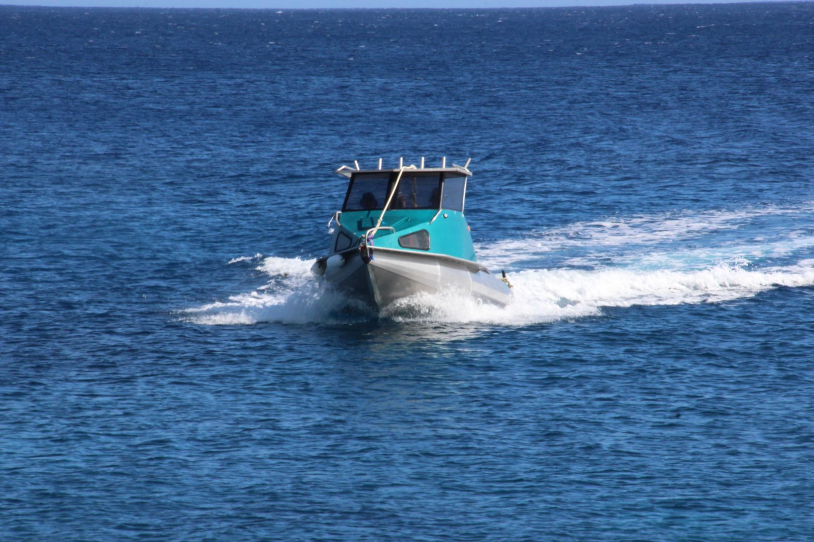 blue fishing boat in ocean