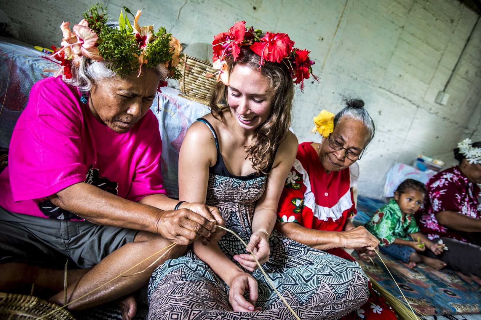 Traveller to Niue engaging in traditional art with local women.