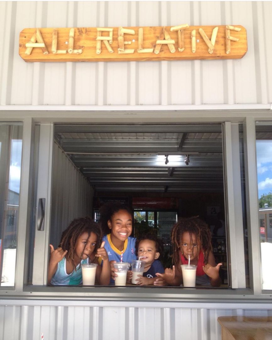 a group of people sitting at a table with cups in front of a sign