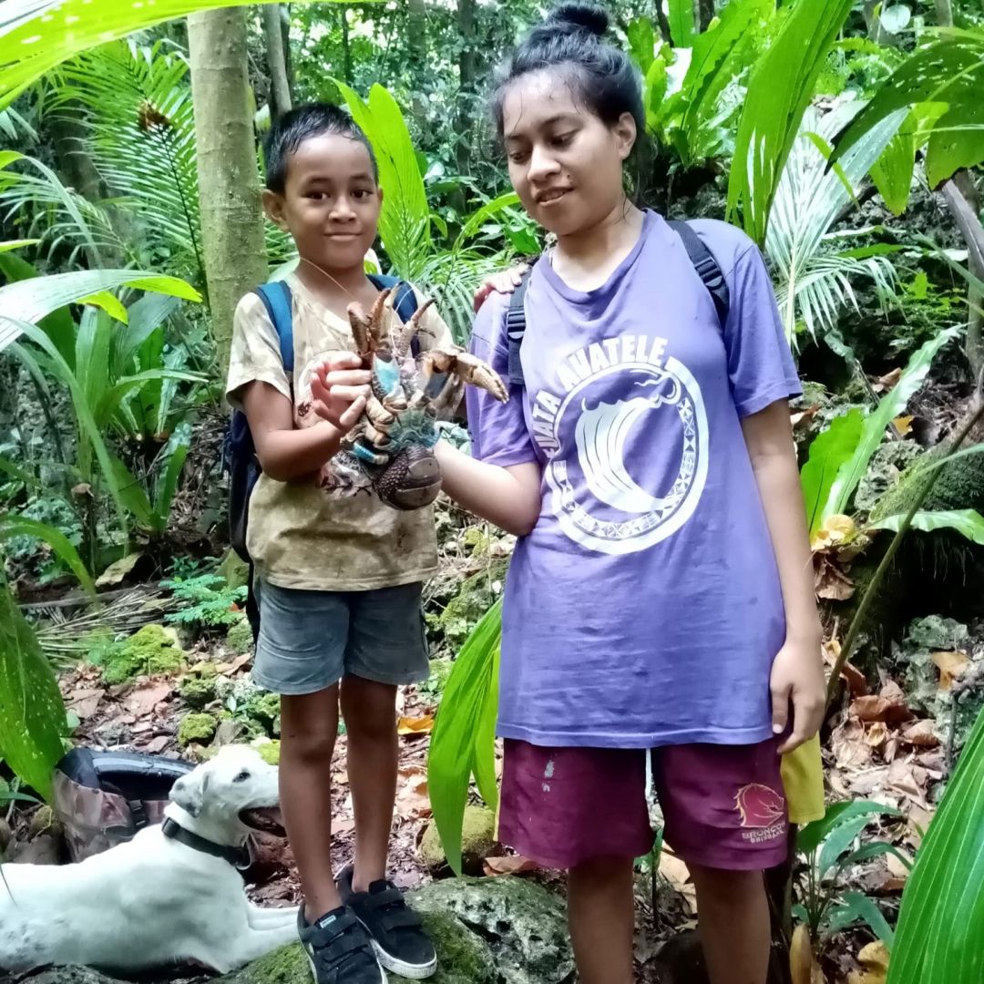 a man and a woman standing in front of a jungle