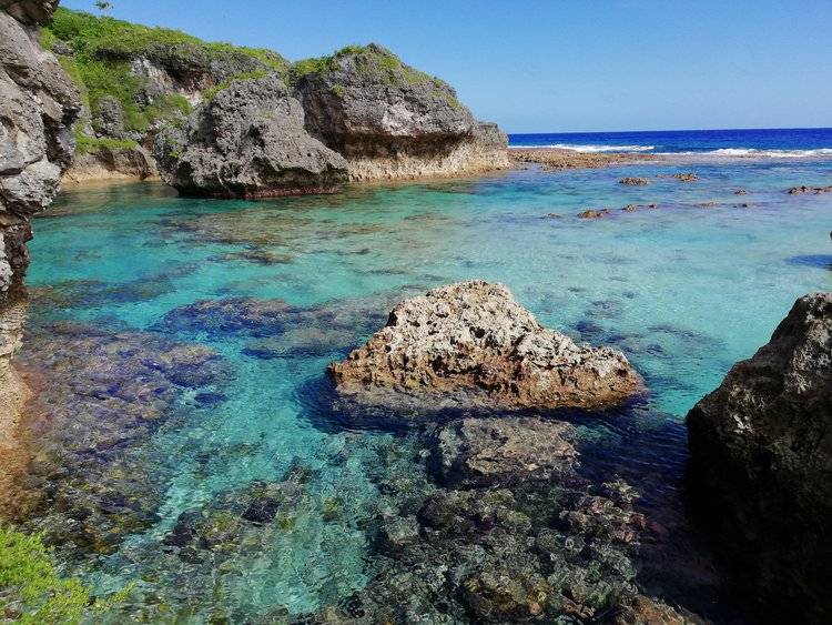 a rocky beach with blue water