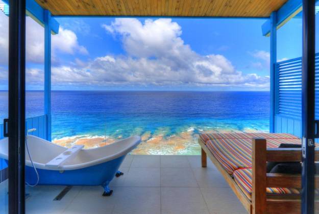 a pool and a deck overlooking the ocean at Lau's Getaways