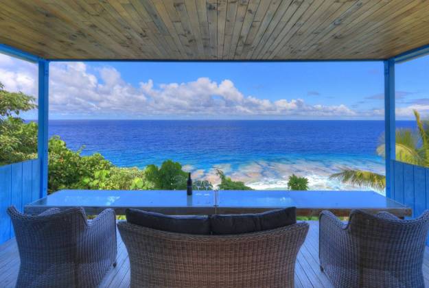 a deck with chairs and a view of the ocean