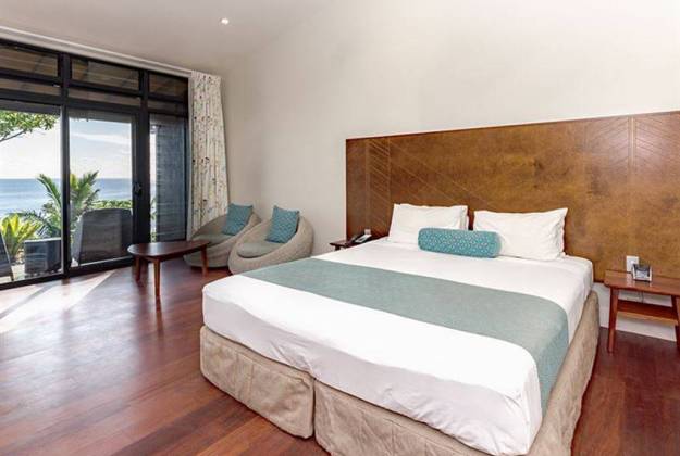 room with white bed and sliding doors at Scenic Matavi Resort