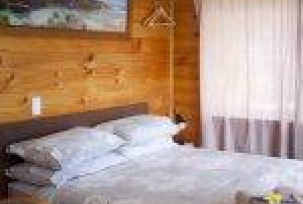 bedroom with white bedding and wooden walls